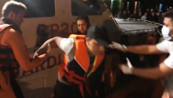 Спасатели помогали сойти на берег выжившим в кораблекрушении у Лампедузы