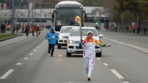 Ирина Роднина несет факел с огнем во время старта эстафеты Олимпийского огня в Москве