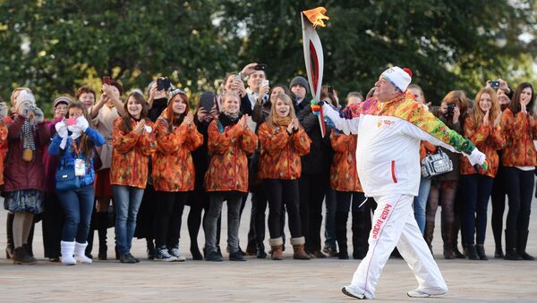 Шаварш Карапетян несет факел с огнем во время старта эстафеты Олимпийского огня в Москве