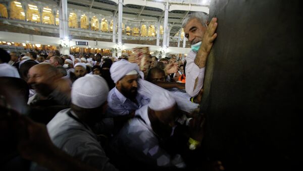 Мусульманские паломники прикасаются к Каабе в Большой мечети Мекки