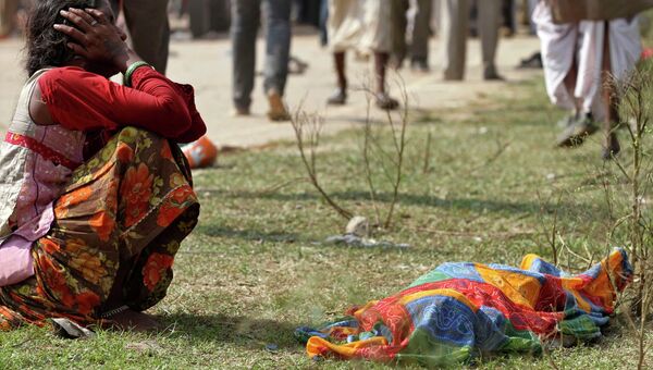 Женщина оплакивает погибшего в результате давки вблизи города Ратанграх, штат Мадхья-Прадеш