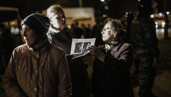 Местные жители в районе Бирюлево Западное в Москве рассматривают ориентировку с фотографией предполагаемого убийцы Егора Щербакова