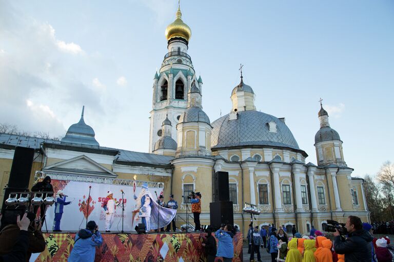 Дед Мороз на сцене у Софийского собора демонстрирует зрителям Олимпийский факел