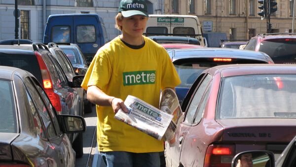 Молодой человек, раздающий газету Метро