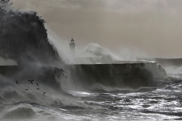 Волны разбиваются о маяк во время шторма в Юго-Восточной Англии