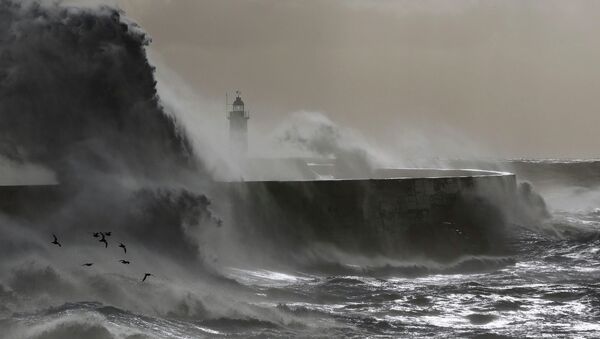 Волны разбиваются о маяк во время шторма в Юго-Восточной Англии