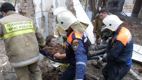 Сотрудники МЧС эвакуируют пострадавшего с места обрушения крыши на складе в Ростовской области. Событийное фото.
