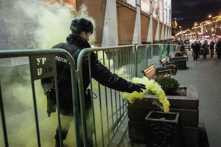 Сотрудник правоохранительных органов выбрасывает файер в урну во время акции Стратегия-31