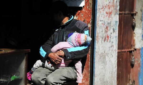 Мужчина с ребенком сидит в лавке на одной из улиц Катманду