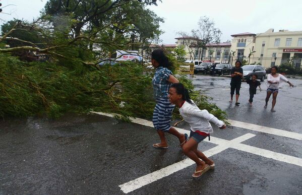 Местные жители бегут по улице во время урагана на Филиппинах