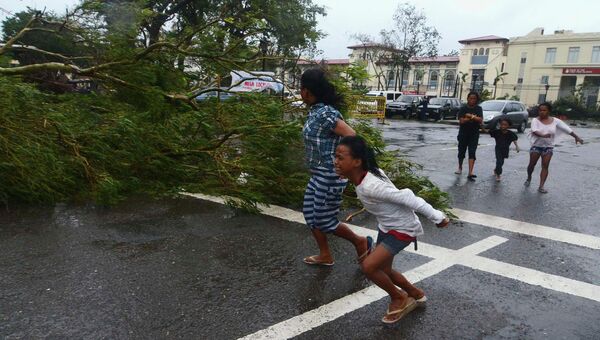 Местные жители бегут по улице во время урагана на Филиппинах