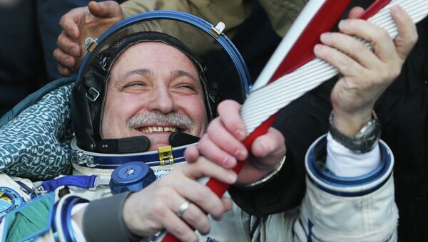 Российский космонавт Федор Юрчихин держит в руках Олимпийский факел. Фото с места события
