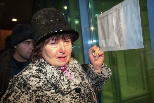 Плачущая женщина у списка погибших во втором терминале аэропорта Казани