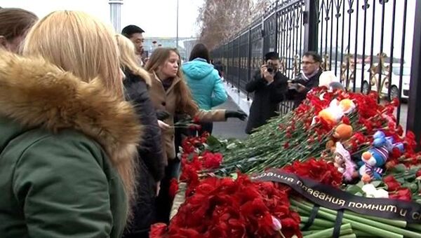 Люди несут цветы и игрушки к аэропорту в Казани, где разбился самолет