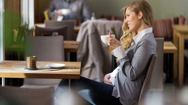 Беременная женщина в кафе, архивное фото
