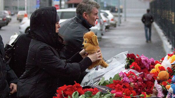 Алые гвоздики несут горожане к месту трагедии в Казани