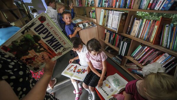 Школьники читают книги  в библиотеке. Архивное фото
