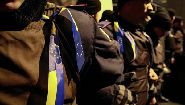 Ленты с украинскими флагами и флагами Евросоюза на полицейских во время митинга в поддержку евроинтеграции, Киев