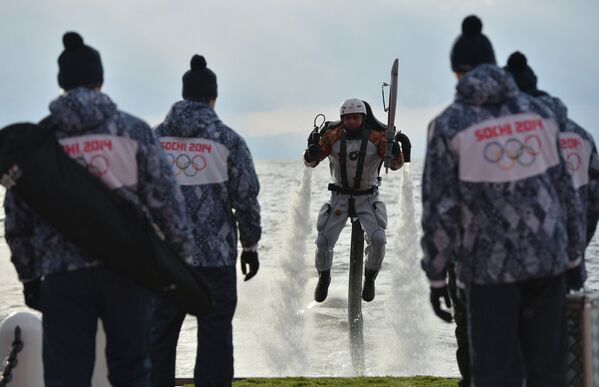 Факелоносец Михаил Чуев на летательном аппарате во время эстафеты Олимпийского огня на озере Байкал