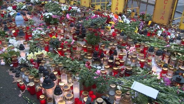 Жители Риги несли цветы и свечи к разрушенному ТЦ в день траура