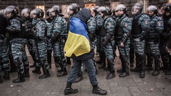 Сторонник евроинтеграции Украины и сотрудники милиции у здания правительства страны в Киеве