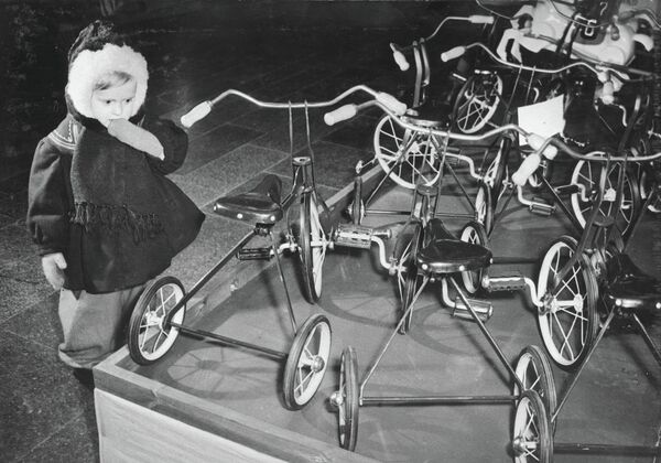 Ребенок смотрит на велосипеды в ГУМе