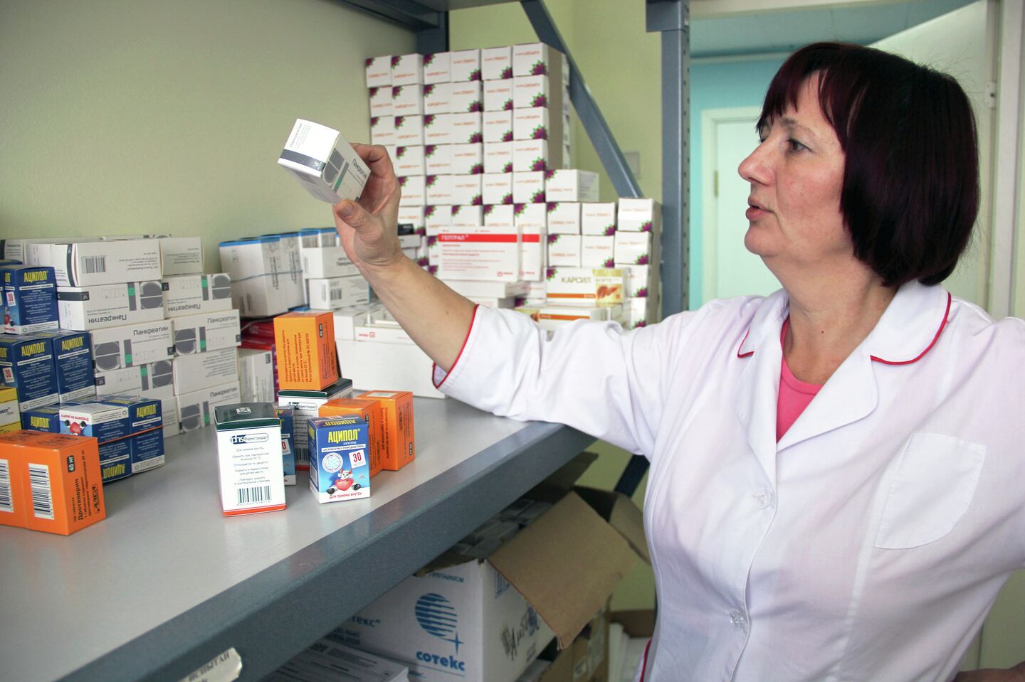 Сотрудница томского центра Анти-СПИД разбирает лекарства для ВИЧ-положительных людей