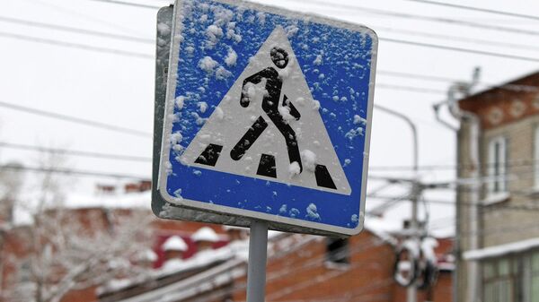 Знак пешеходного перехода, припорошенный снегом. Архивное фото