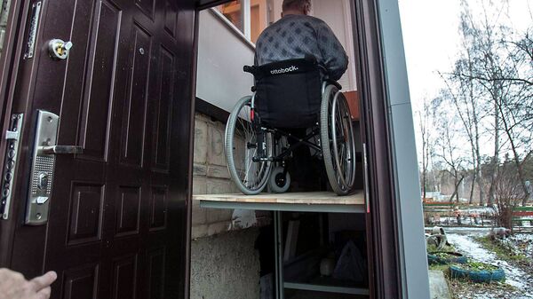 Станислав Пачгин на автоматической платформе для спуска-подъема коляски в своем подъезде
