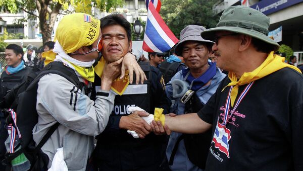Протестант обнимается с полицейским во время перемирия после столкновений в Бангкоке