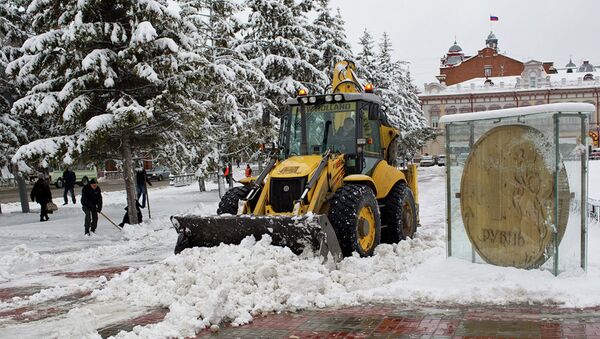 Экскаватор убирает снег на Новособорной площади Томска
