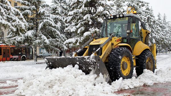 Экскаватор убирает снег на Новособорной площади Томска