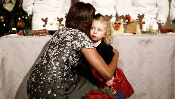 Первая леди США Мишель Обама успокаивает маленькую девочку после инцидента с собакой Санни