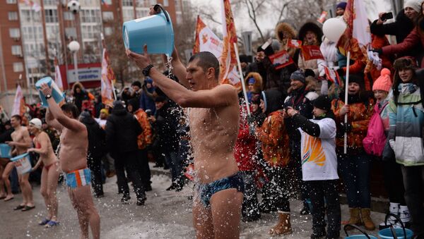 Жители города обливаются водой во время эстафеты Олимпийского огня в Новосибирске