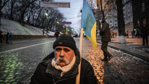 Мужчина с флагом Украины возле здания кабинета министров Украины в Киеве