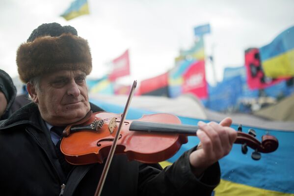 Мужчина играет на скрипке на митинге сторонников евроинтеграции Украины на площади Независимости в Киеве