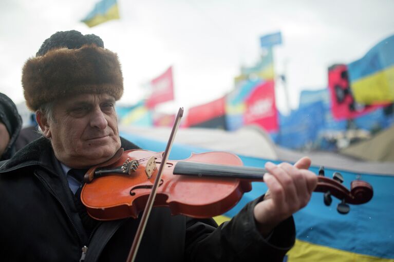 Мужчина играет на скрипке на митинге сторонников евроинтеграции Украины на площади Независимости в Киеве