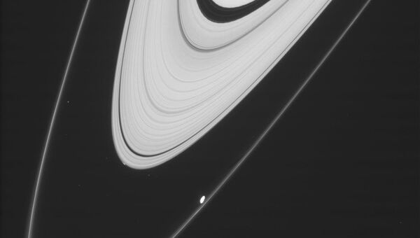 Белое пятно у тонкого внешнего кольца – это спутник Сатурна Прометей,  небольшое пятнышко у толстого кольца – следы нового спутника Пегги