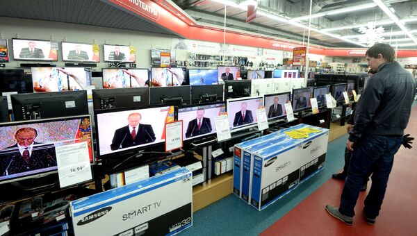 Покупатели смотрят обращение президента Владимира Путина к Федеральному собранию в магазине М-видео в Москве. Архивное фото