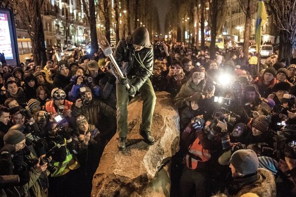 Участники акции разбивают памятник Ленину, сброшенный с пьедестала на Бессарабской площади в Киеве