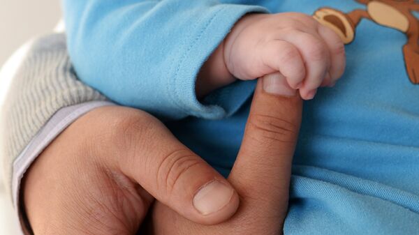 Рука младенца и матери. Архивное фото