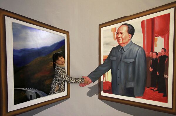 Девочка позирует на фоне 3D-картины с изображением Мао Цзэдуна на выставке в Бинжоу