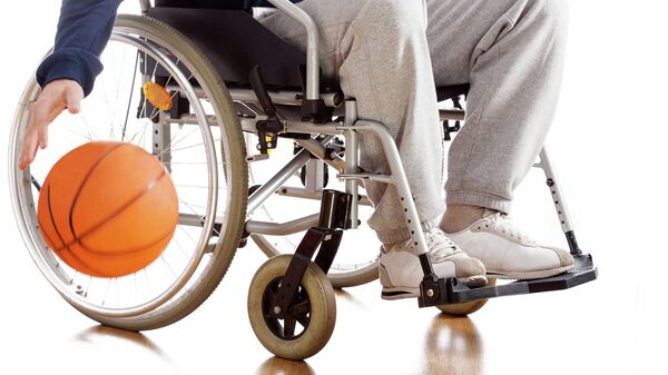 Мужчина в инвалидном кресле занимается спортом