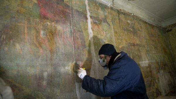 Реставратор за работой по восстановлению коммунистических фресок 30-х годов, обнаруженных в полуразрушенном доме Стройбюро ансамбля зданий Болшевской трудовой коммуны