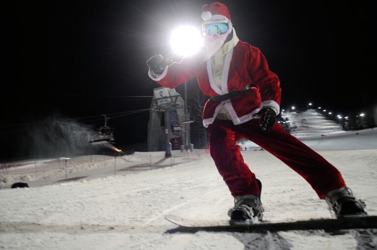 Лыжник в костюме Деда Мороза на одном из склонов в Красноярске