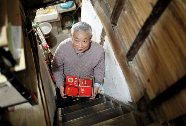 Китайский пенсионер несет старые книги о Мао Цзэдуне