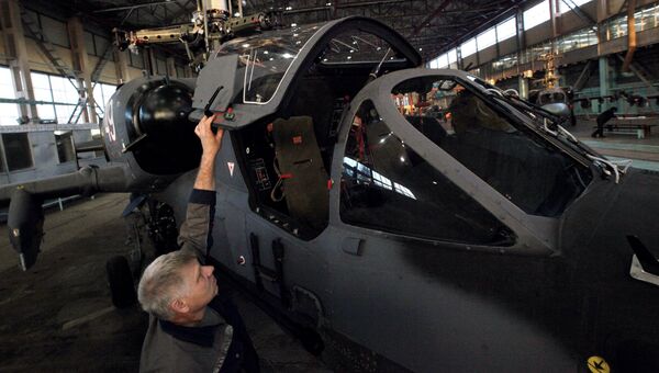 Рабочий завода осматривает новый вертолет Ка-52, архивное фото