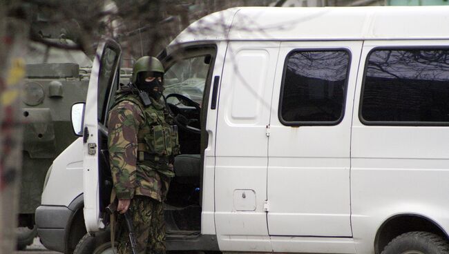 Сотрудник правоохранительных органов у автомобиля во время спецоперации по уничтожению боевиков. Архивное фото