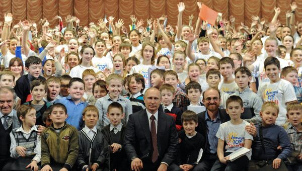Президент России Владимир Путин (в центре) фотографируется с участниками Сводного детского хора России, фото с места события