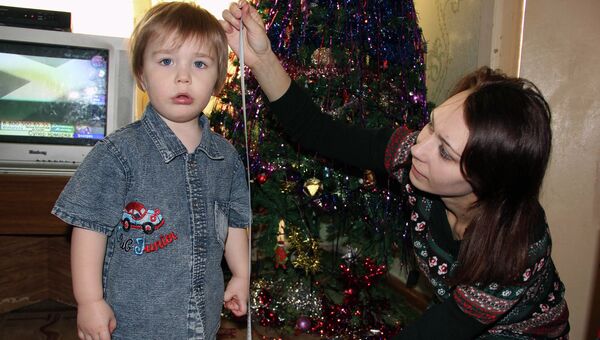Светлана Шандрова измеряет сантиметром рост своего сына - томского богатыря Даниила